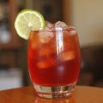 Final presentation of a Dr Pepper cocktail, garnished with lime, showcasing the vibrant drink