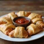 Delicious Savory Crescent Pizza Rolls ready to be enjoyed, served with marinara sauce.