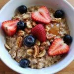 Healthy breakfast with oatmeal, mixed berries, nuts, and honey for gut health