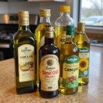 Assorted cooking oils like olive, canola, and sunflower on a kitchen counter for cooking and cleaning