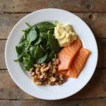 Healthy balanced meal with spinach, walnuts, and salmon to support hormone health.