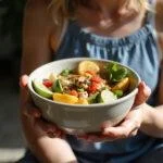 Person practicing mindful eating with a vibrant bowl of healthy food, showcasing focus and tranquility.
