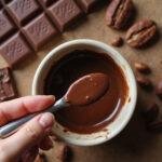 Close-up of melted chocolate with chocolate bars and cocoa beans in the background, showcasing mood-boosting chocolate recipes.