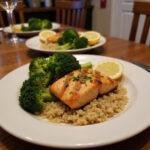 Healthy anti-inflammatory dinner featuring grilled salmon, steamed broccoli, and quinoa on a plate in a cozy kitchen setting.