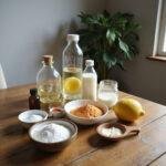 Natural cleaning ingredients like vinegar, baking soda, lemon, and essential oils on a wooden table for homemade cleaning recipes.