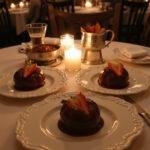Romantic dessert table with strawberries and fondue under candlelight, ideal for a romantic evening.