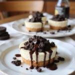 A realistic image of Oreo Cheesecake Cookie Cups plated on a white dish in a cozy home kitchen setting, showcasing the creamy filling topped with Oreo crumbs and chocolate drizzle, with warm lighting and homey decorations around.