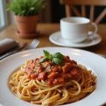 A plated Rotel Pasta Fiesta on a cozy wooden table with herbs garnish, set in a warm kitchen environment, emphasizing the vibrant colors of the pasta and tomato sauce.