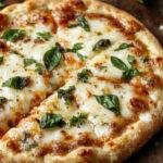 A delicious 3 Cheese Lemon Basil Pizza topped with melted cheese, fresh basil leaves, and lemon zest slices on a crispy crust.