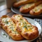 Realistic image of homemade cheesy breadsticks served on a white plate in a cozy home setting, with melted cheese, herbs, and golden crust, on a wooden table with soft natural light.