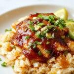 A plate of Honey BBQ Chicken Rice topped with grilled chicken drizzled in glossy honey BBQ sauce, served alongside steamed vegetables.