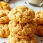 Golden baked mango cookies with a chewy interior and a slightly crispy exterior, garnished with dried mango pieces.