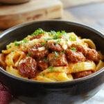 A flavorful plate of One-Pot Bold Honey BBQ Sausage Pasta garnished with fresh herbs, showcasing a rich and smoky sauce mixed with sausage and pasta.
