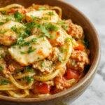 A colorful plate of One Pot Ground Chicken Fajita Pasta garnished with fresh cilantro and lime slices, showcasing tender chicken, vibrant vegetables, and pasta.