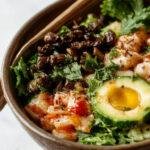 A vibrant vegan poke bowl featuring fresh cubes of tofu, colorful vegetables, and toasted sesame seeds over a bed of rice.
